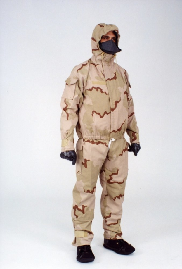 Mann in Tarnmuster-Schutzoverall und passender Kapuzenmaske vor einem weißen Hintergrund.