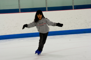 Eine Person in Kleidung fährt auf dem Eis mit Polen am oberen Bildrand.
