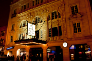 Ein gelbes Gebäude mit einem weißen Schild, auf dem 'Metro' steht, über Geschäften an der Vorderseite.