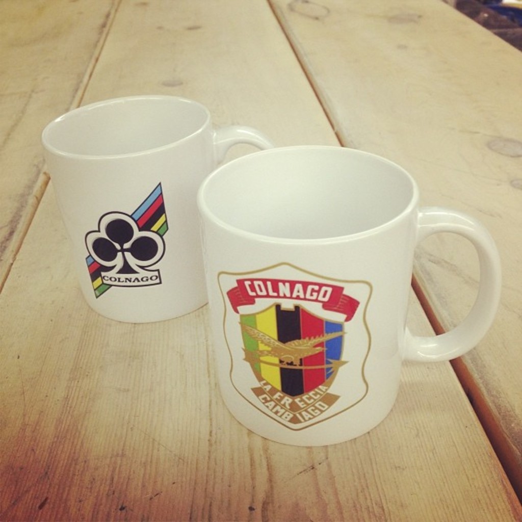 Zwei Tassen auf einer Plattform, jede mit einem eigenen Logo.