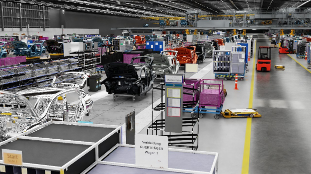Große Fabrik mit mehreren Autos auf einer Fertigungsstraße, metallische Strukturen an den Seiten, eine Wand im Hintergrund und an der Decke montierte Lampen, wahrscheinlich eine Volkswagen-Fabrik in Deutschland.