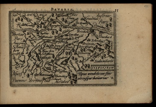 Ein altes Buch mit einer detaillierten Karte von Bayern, einschließlich Städte und Ortschaften, vor einem schwarzen Hintergrund.