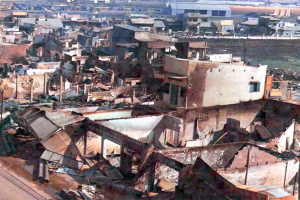 Mehrere Gebäude sind sichtbar, einige davon scheinen eingestürzt zu sein.