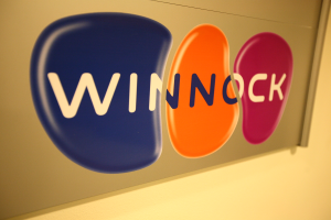 Ein buntes Schild an einer Wand trägt die Aufschrift "Winnock", was darauf hinweist, dass es sich um eine Börse handelt.