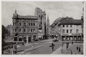 Schwarz-weiß-Foto einer belebten Münchner Stadtstraße mit Fußgängern, Fahrzeugen und Gebäuden, Bäumen im Hintergrund und Text unten.
