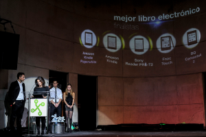 Vier Personen auf der linken Seite, eine Frau hält einen Vortrag, mit Bildern von Gadgets und ihren Namen im Hintergrund.