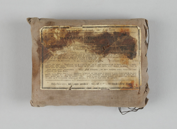 Kleiner Verbandskoffer mit Informationsblatt obenauf.