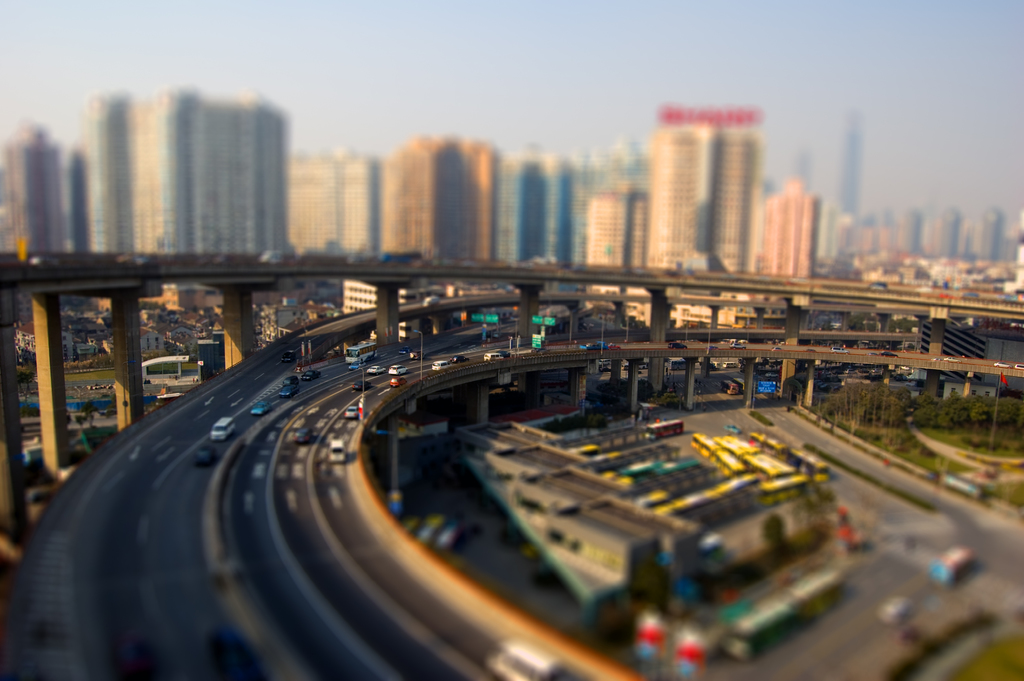 Drei Brücken mit Fahrzeugen und geparkten Bussen, darunter sichtbare Gebäude.