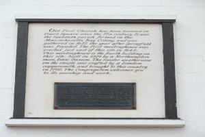 Plaque an einer Gebäudewand beschriftet mit "National Register of Historic Places" in fetter Schrift und einem dekorativen Rahmen aus dunklem Material.