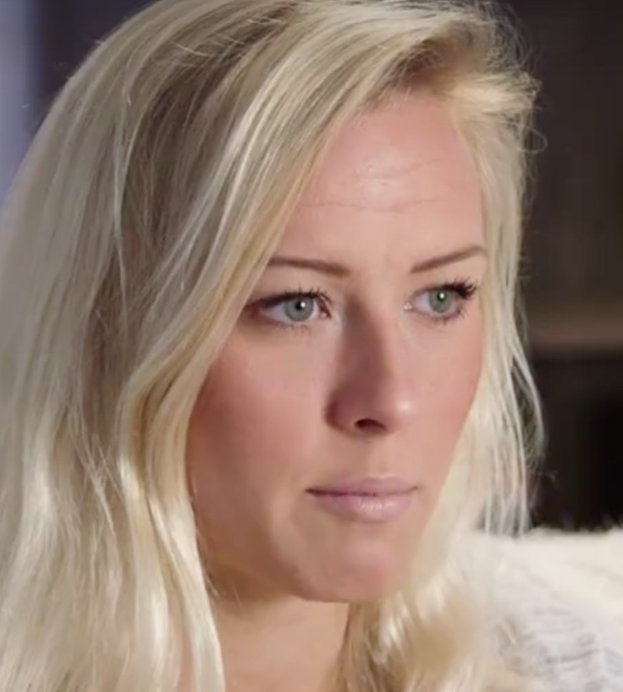 Blonde Frau mit blauen Augen in Not, Vordergrund scharf, Hintergrund unscharf.