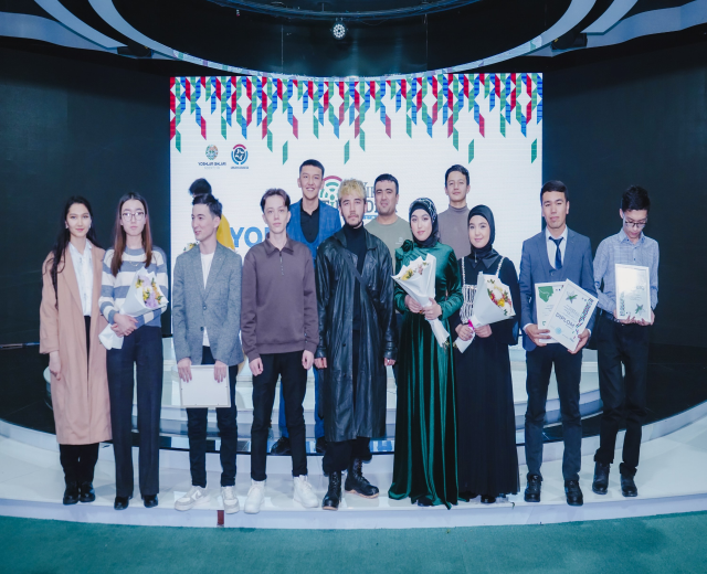 Gruppe von Menschen auf einer Bühne mit Blumensträußen und Urkunden, im Hintergrund ein "Youth Solar Awards 2019"-Plakat